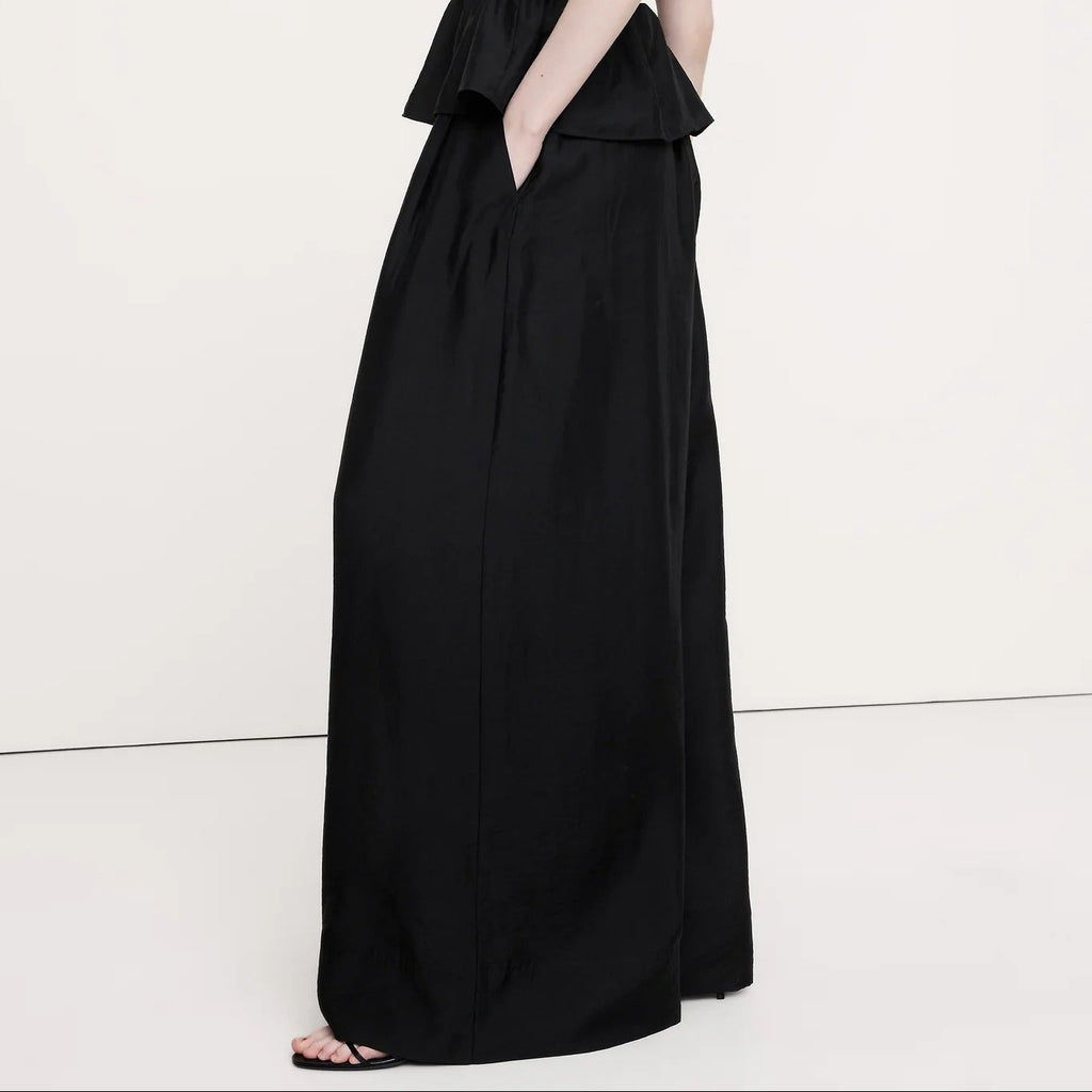 Woman wearing a black sleeveless dress on a white background