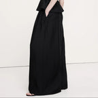 Woman wearing a black sleeveless dress on a white background