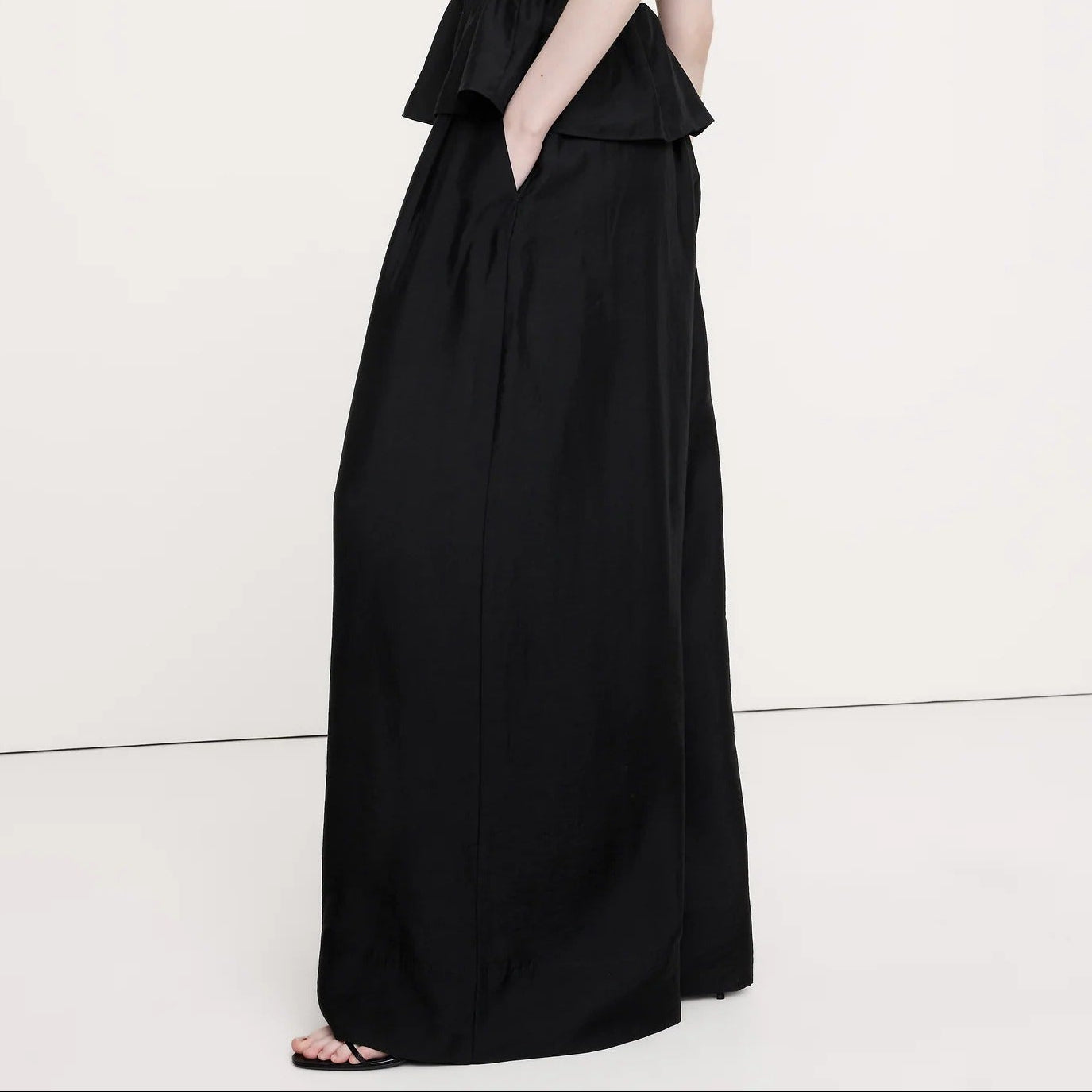 Woman wearing a black sleeveless dress on a white background