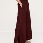 Maroon wide-leg pants worn by a person on a white background