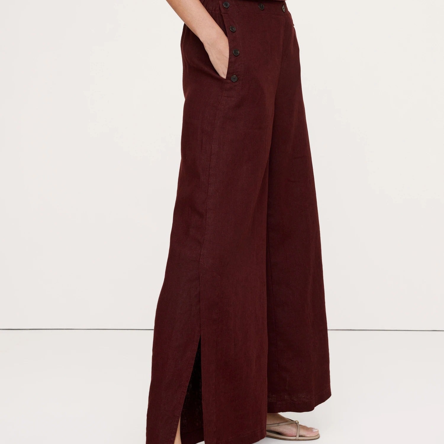 Maroon wide-leg pants worn by a person on a white background