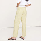 Woman wearing a white shirt and beige pants on a white background